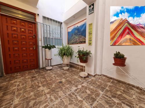 a hallway with a door and potted plants at WASI in Cusco