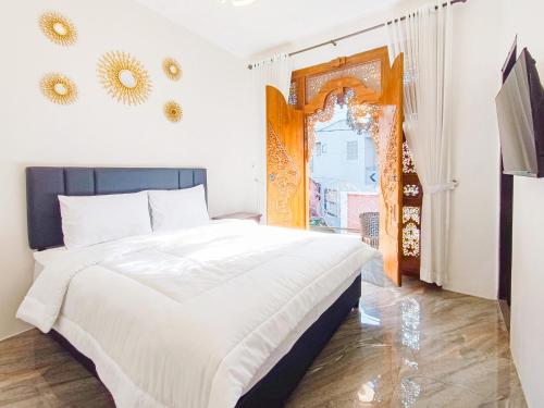a bedroom with a white bed and a window at MAHA LIVING Dieng Syariah RedPartner in Dieng