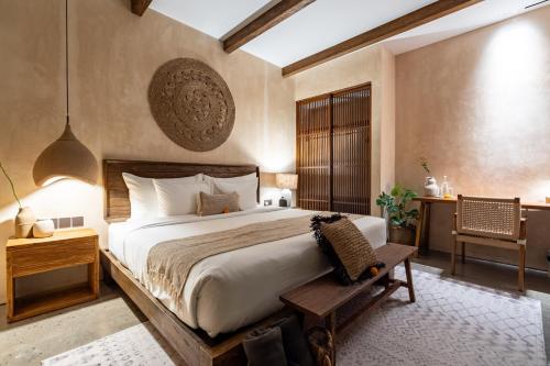 une chambre avec un grand lit et une table dans l'établissement Nawasena Villa B - Earthy Luxury Villa, Walk to Beach in Pererenan, à Cemagi