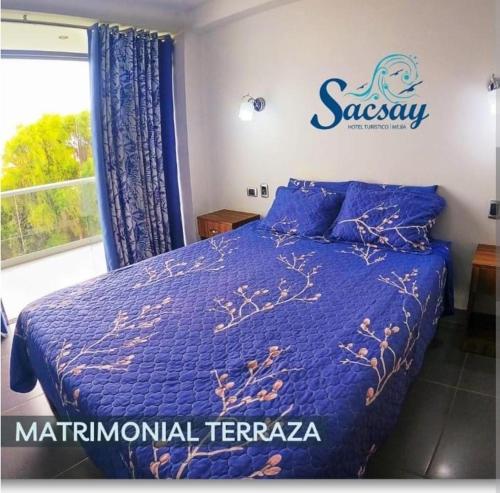a bedroom with a blue bed and a window at Sacsay Mejía in Islay