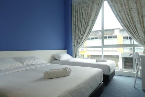 a hotel room with two beds and a window at Lodge 10 Hotel in Seremban