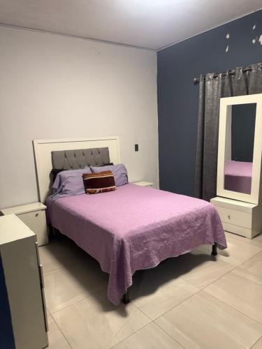 a bedroom with a bed with a purple blanket at Casa sonora in Cedro