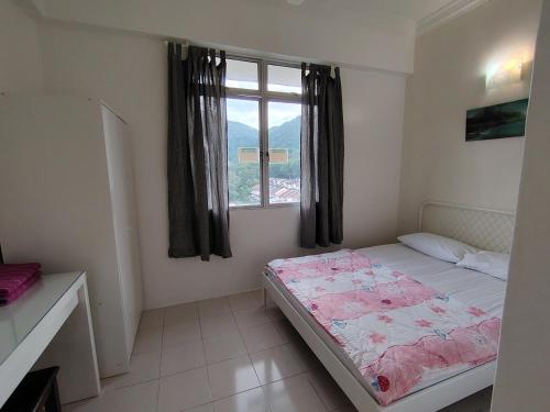 ein kleines Schlafzimmer mit einem Bett und einem Fenster in der Unterkunft Penang Tg Bungah Permai Ria Apartment in Tanjung Bungah