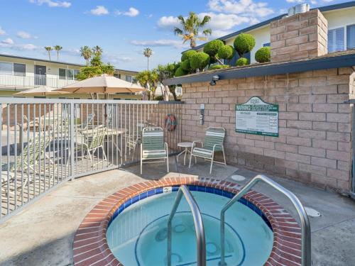 a swimming pool with chairs and a table and a patio at Beautiful 2 Bed Beach Getaway #115 condo in Carpinteria