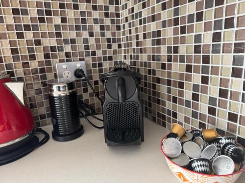 a coffee maker on a counter next to a basket of cups at The SCOOP in Queenscliff