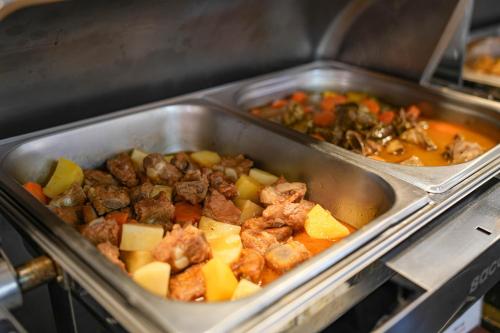 a pan of food with meat and vegetables at Hoang Long Hotel Phan Thiết in Phan Thiet