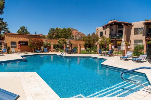 a large swimming pool with chairs and a building at Stylish Condo in Village Oak Creek with Pool and Hot Tubs in Sedona