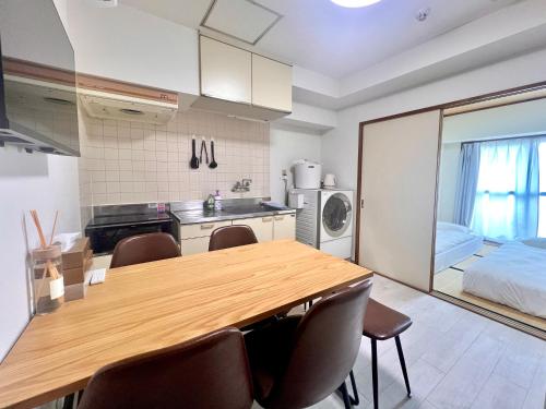 a kitchen and dining room with a wooden table and chairs at LoveAsakusa Stay 6 Iriya Station Ueno Station 2ー6人 エレベーター WIFI 浅草 新宿 渋谷 銀座 築地 浅草 原宿近い in Tokyo