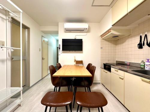 a kitchen with a table and chairs in a room at LoveAsakusa Stay 6 Iriya Station Ueno Station 2ー6人 エレベーター WIFI 浅草 新宿 渋谷 銀座 築地 浅草 原宿近い in Tokyo