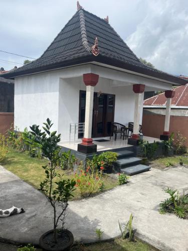 a small white house with a black roof at Batur OASE in Kubupenlokan