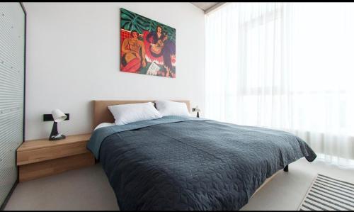 a bedroom with a bed and a painting on the wall at Loft студія в Аркадіі з шикарним видом города in Odesa