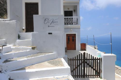 a white house with stairs leading to a door at Oxo Kamara Apartment in Karpathos Town