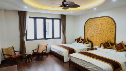 a hotel room with two beds and a ceiling at Maison Homestay Pho Bien 17, Ocean Park 3 in Ðình Loan