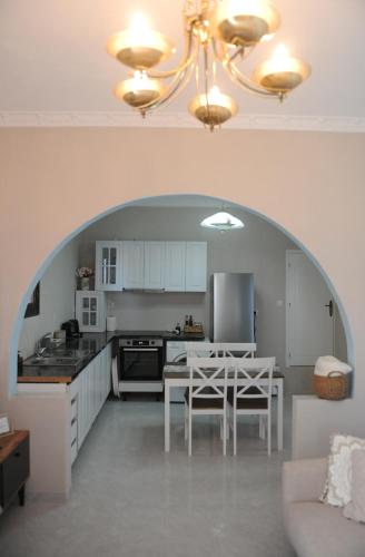 a kitchen with a table and a kitchen with an archway at Oxo Kamara Apartment in Karpathos Town