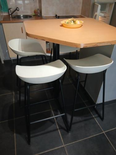 - une table et deux chaises blanches dans la cuisine dans l'établissement A 30m de la place Med, à Canet