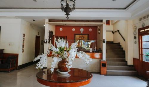 a lobby with a vase of flowers on a table at Hotel Wisma Dago in Bandung