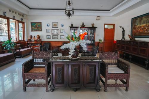 a living room with a table with a vase of flowers on it at Hotel Wisma Dago in Bandung