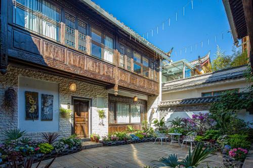 a courtyard of a building with a table and chairs at Yueju Designer Homestay in Lijiang