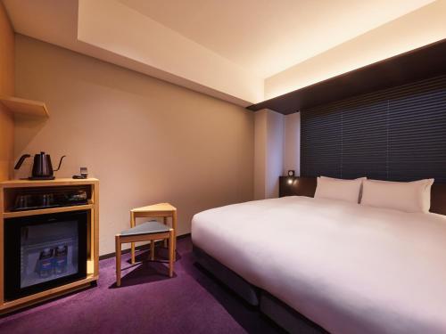 a hotel room with a bed and a tv at Agora Kyoto Shijo in Kyoto