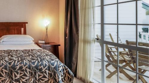 a bedroom with a bed next to a balcony at Wairakei Resort Taupo in Taupo