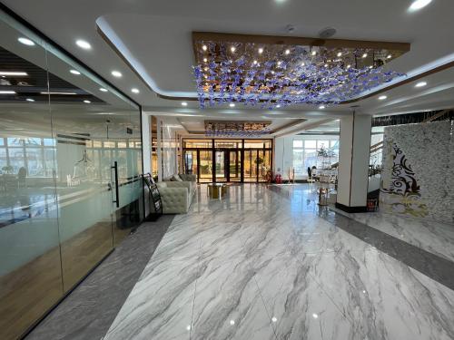 a lobby with a chandelier and marble floors and a building at Numt Guren Resort in Ulaanbaatar