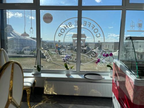 a window of a store with a view of a wheel at Numt Guren Resort in Ulaanbaatar