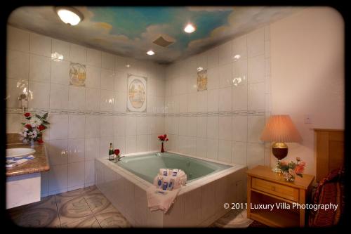 a bathroom with a bath tub and a sink at The Palace Inn in Oxnard