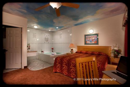 a bedroom with a bed and a bath tub at The Palace Inn in Oxnard