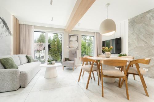 a living room with a table and a couch at Wonder Home - Domki górskie wolnostojące z prywatnymi tarasami - zielona okolica in Karpacz