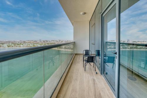an office with a balcony with a view of the city at Coastal Bliss 1BHK Sea View Apartment by Czechin in Ras al Khaimah