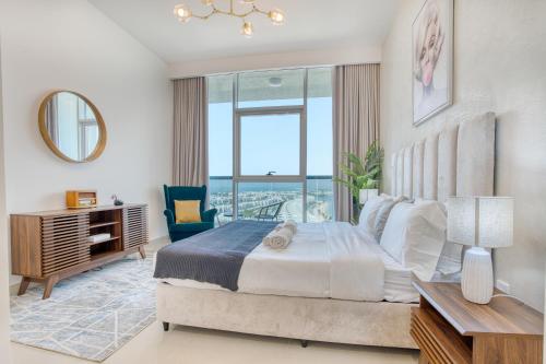 a bedroom with a bed and a large window at Coastal Bliss 1BHK Sea View Apartment by Czechin in Ras al Khaimah