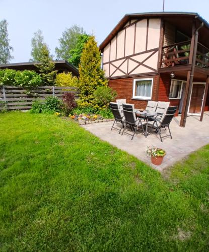 a patio with chairs and a table in front of a house at Saulkrasti Beach Cottage 2 in Saulkrasti