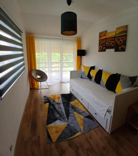 a living room with a white couch and a rug at Saulkrasti Beach Cottage 2 in Saulkrasti