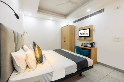 a bedroom with a bed and a blue chair at Hotel Admire Inn Sec - 104 By ASPL in Noida