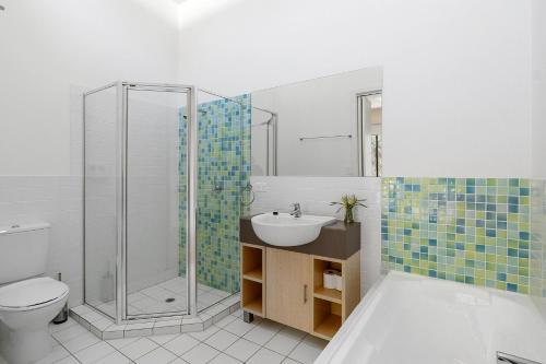 une salle de bain avec un lavabo, une douche et des toilettes dans l'établissement South Shores Villa 50, à Normanville