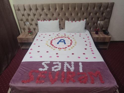 a bed with a sign on it with aaimfw at Elit Continental Hotel in Baku