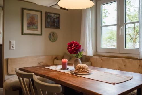 a dining room table with a candle and a vase of flowers at Das Heinz - Your Austrian Home in Puchen