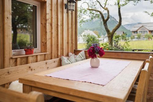 a wooden table with a vase of flowers on it at Das Heinz - Your Austrian Home in Puchen