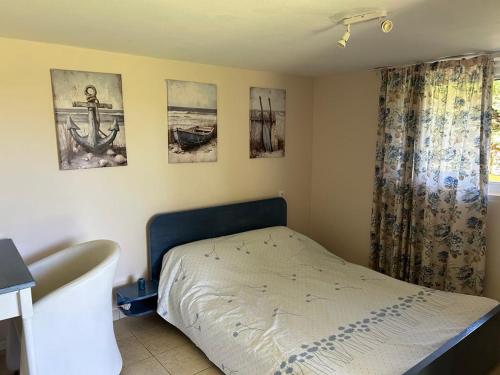 Un dormitorio con una cama y cuadros en la pared. en Tiny Comfort House, en Kyllini