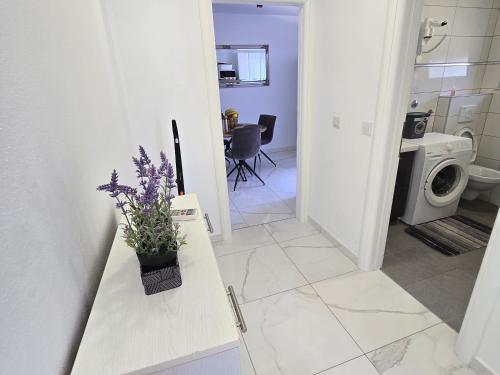 a bathroom with a counter with purple flowers on it at VILA KIKA in Rogoznica