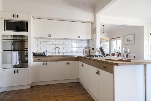 a kitchen with white cabinets and a counter top at Serenity in Red Hill - Winery Bliss & Coastal Beauty in Red Hill South