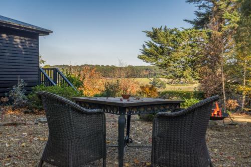 two chairs and a table in a yard at Serenity in Red Hill - Winery Bliss & Coastal Beauty in Red Hill South