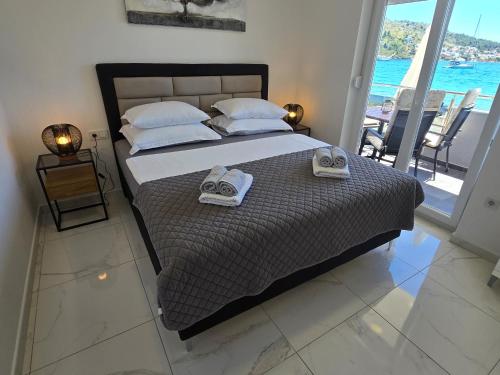 a bedroom with a bed with two towels on it at VILA KIKA in Rogoznica