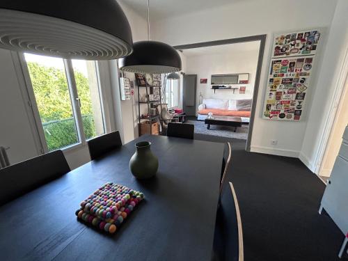 une table à manger avec un vase au-dessus dans l'établissement Super appart à Clamart 3 pièces - 7 min gare, à Clamart