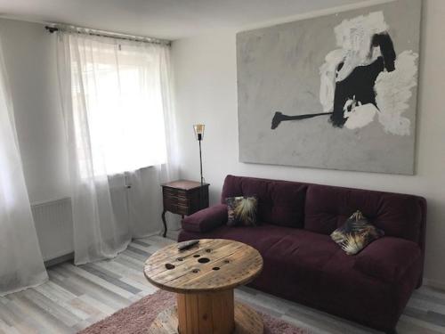 a living room with a purple couch and a table at Möbliertes Wohnen auf Zeit im Extertal in Extertal