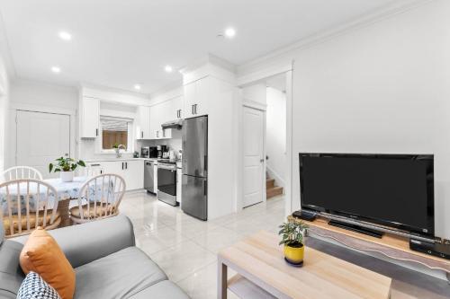 a living room with a couch and a large tv at Modern Private 3BR House in Vancouver