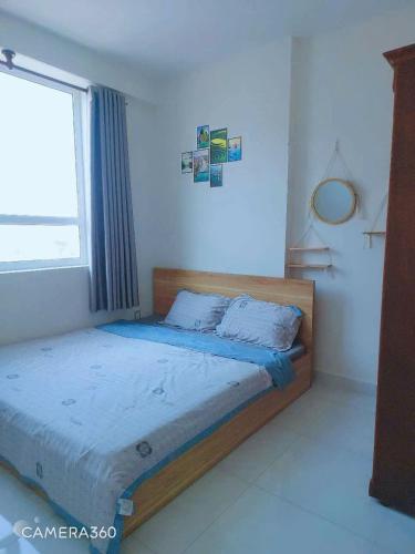 a bedroom with a bed in a room with a window at Nắng Home in Phan Rang