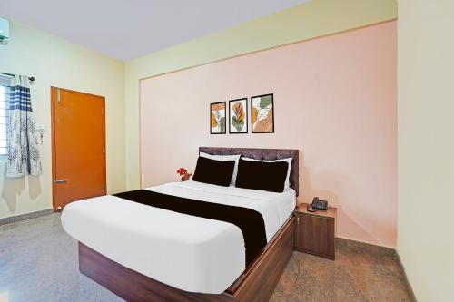 a bedroom with a large bed with white sheets at Super Hotel O Yeshwanthpur Formerly Stay Comforts in Bengaluru