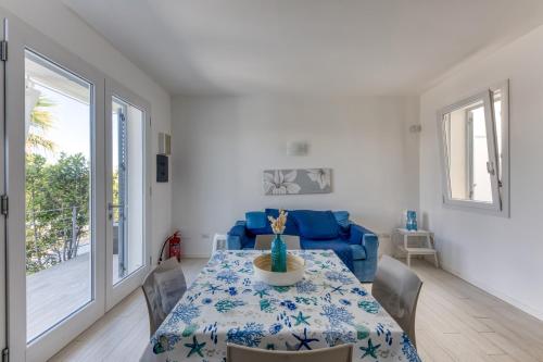 a dining room with a table and a blue couch at Villetta Alma Maldive Del Salento in Marina di Pescoluse