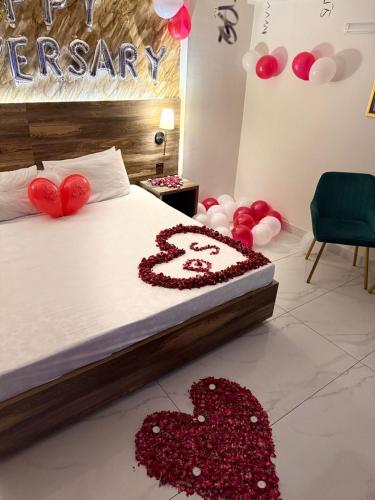 a bedroom with a bed with two hearts on it at Tulip Hotel in Karachi